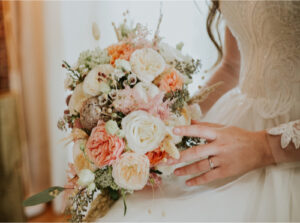 Flower vendor at the Rochester Bridal Show showcasing beautiful wedding floral arrangements